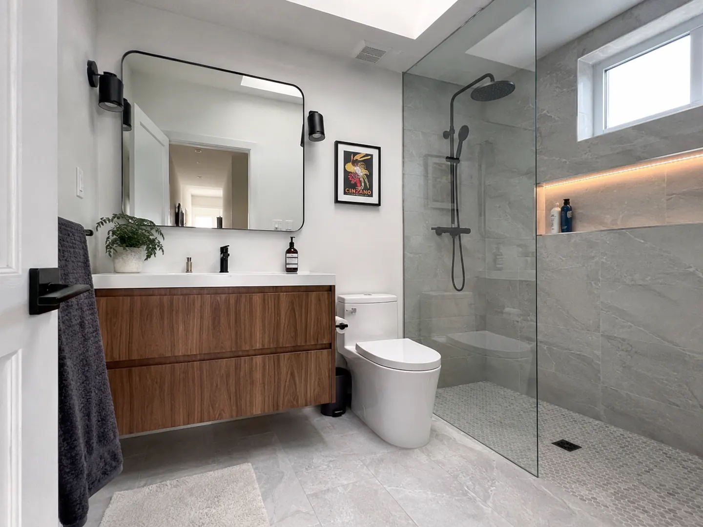 Renovated bathroom in Etobicoke with a walnut floating vanity, black fixtures, and a curbless walk-in shower
