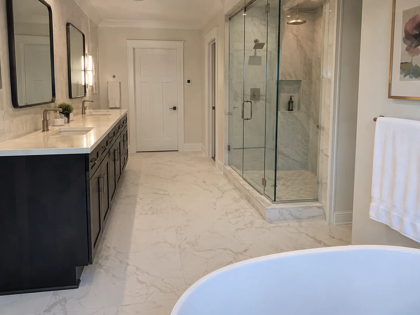 Renovated Toronto bathroom with a black vanity, marble tile floor, a glass corner shower, and a freestanding tub