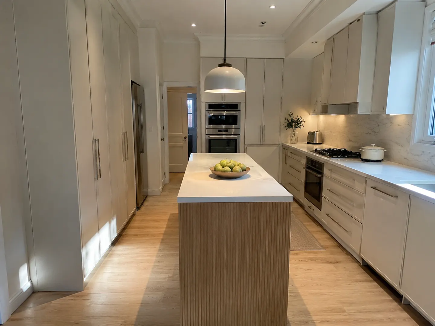 Renovated kitchen in North York with a fluted island, integrated wall ovens, and white oak flooring